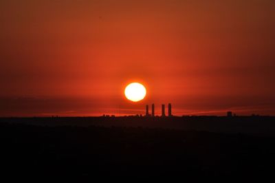 Scenic view of silhouette landscape against orange sky