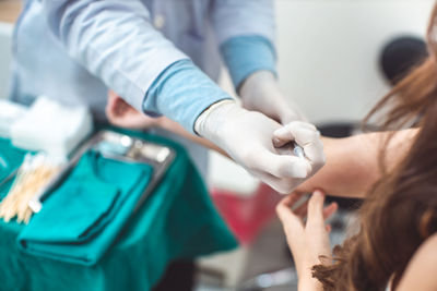 Midsection of doctor vaccinating woman