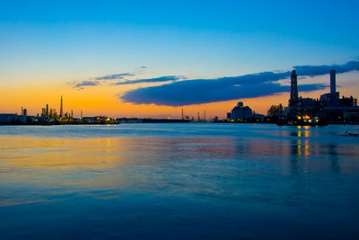 Scenic view of factory against sky during sunset