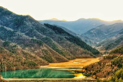 Scenic view of lake and mountains against sky