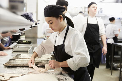 Chef baking baguette in commercial kitchen