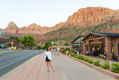 Rear view of woman walking on road against mountain