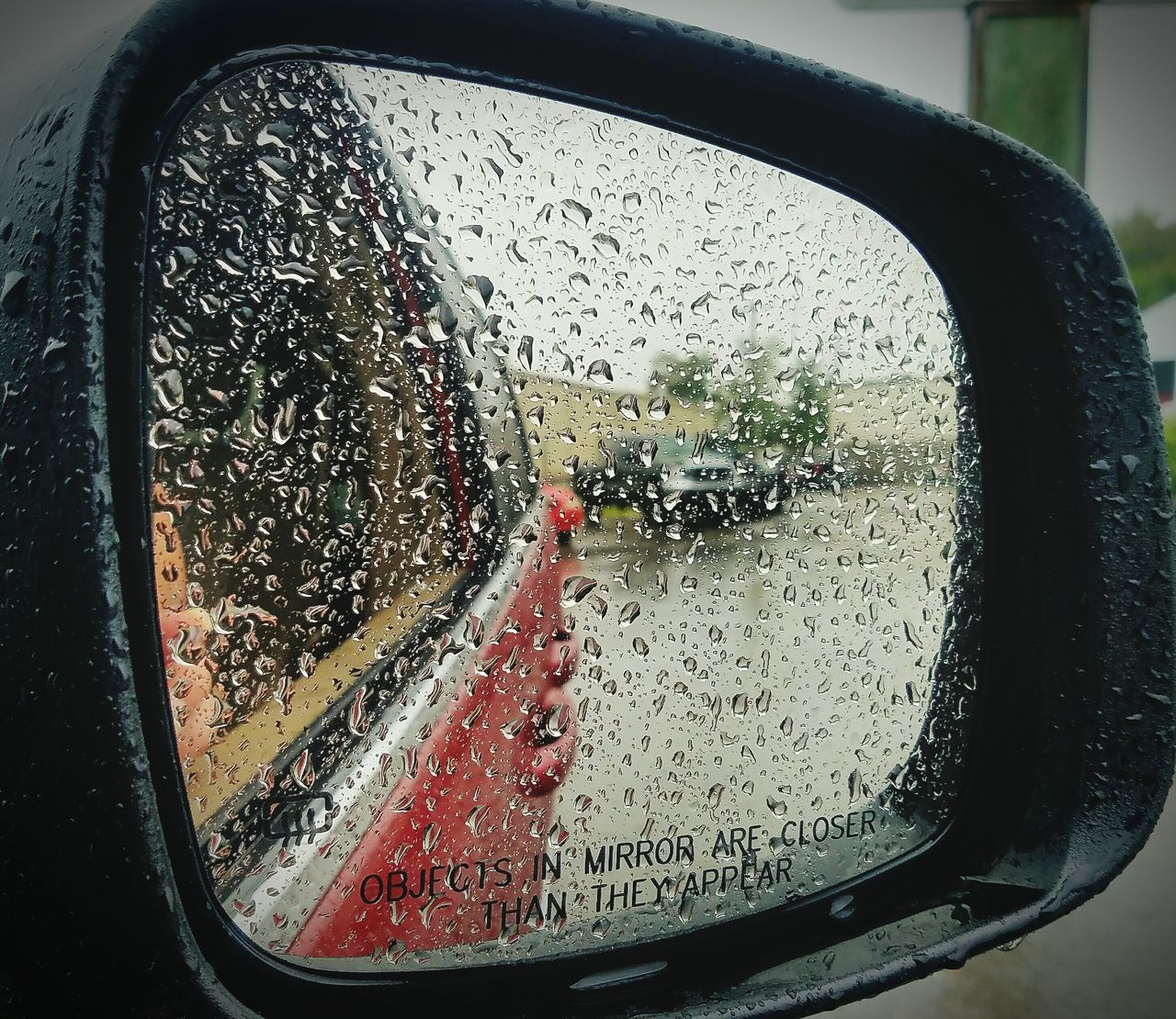 CLOSE-UP OF RAINDROPS ON SIDE-VIEW MIRROR