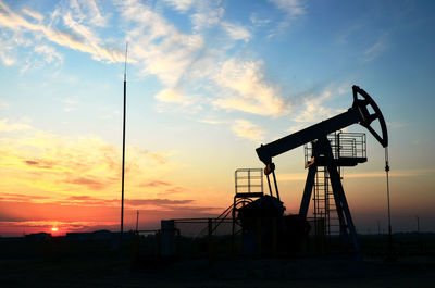 Silhouette crane against sky during sunset