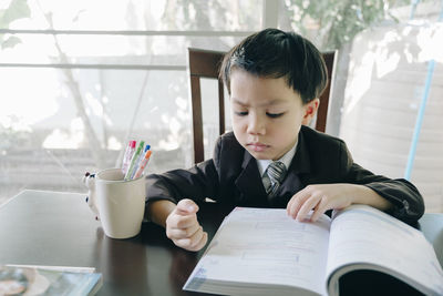 Portrait of boy sitting on table