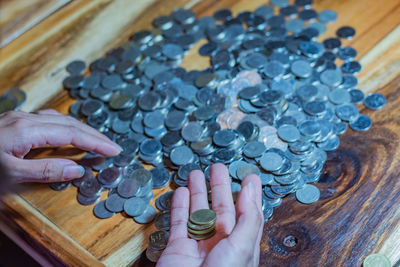 Cropped hands of woman counting coins on table