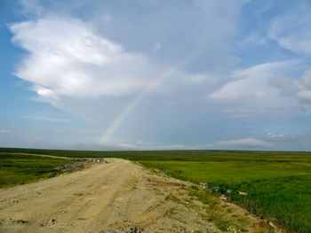 Scenic view of rainbow over road against sky