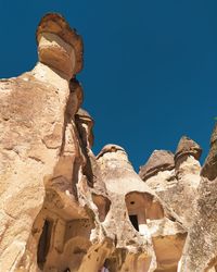 Low angle view of rock formation against blue sky