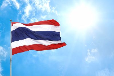 Low angle view of flag waving against cloudy sky