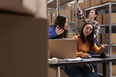 Young woman using laptop while sitting on table