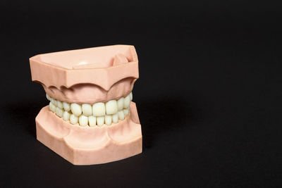 Close-up of dentures against black background