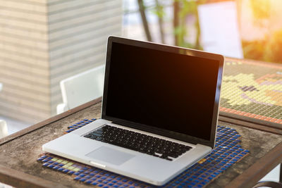 High angle view of laptop with blank screen at sidewalk cafe