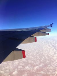Close-up of airplane wing against blue sky