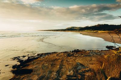 Scenic view of beach against sky during sunset