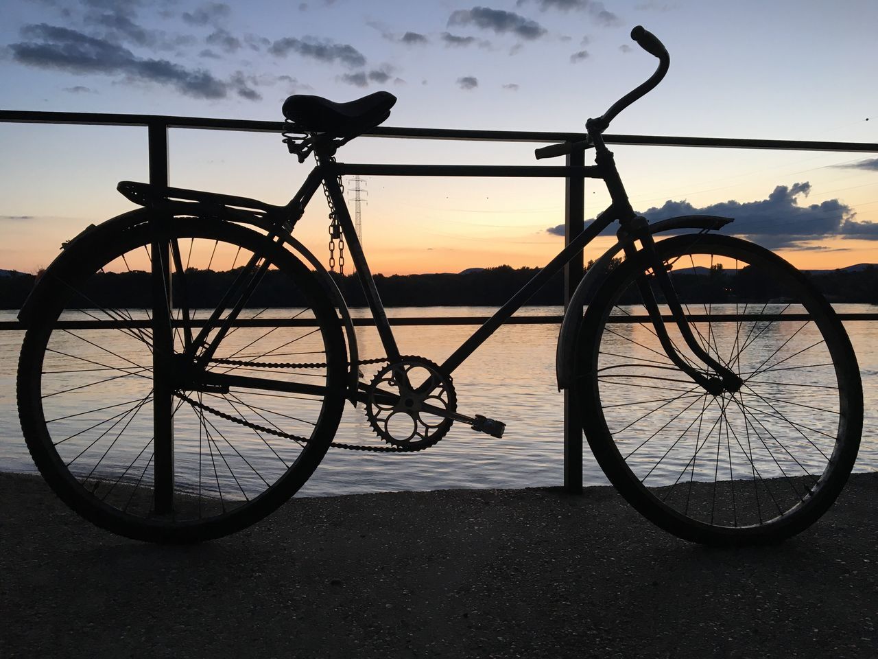 transportation, bicycle, sky, mode of transportation, sunset, road bicycle, water, nature, silhouette, vehicle, cloud, wheel, land, land vehicle, sports equipment, dusk, no people, travel, city, sea, cycling, beach, activity, bicycle wheel, scenics - nature, environment, beauty in nature, outdoors, landscape, dramatic sky, mountain bike, sunlight, tranquility, pedal, tire, back lit, sports