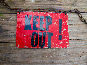 Top view of vintage keep out sign on wooden deck.