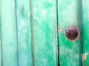 High angle view of rusty keyhole amidst green wooden door