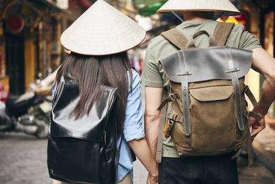 Rear view of man and woman standing on street