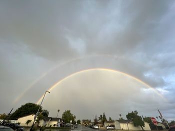 Low angle view of rainbow over buildings in city