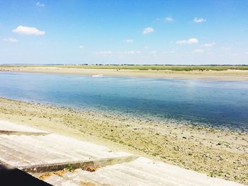 Scenic view of beach against blue sky