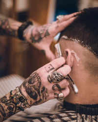 Cropped hands of hairdresser styling hair