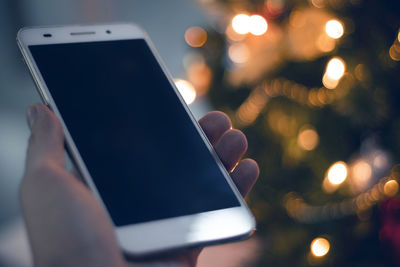 Close-up of hand using mobile phone at night