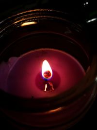 Close-up of lit tea light candles in darkroom