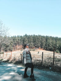 Full length of man standing against trees against clear sky