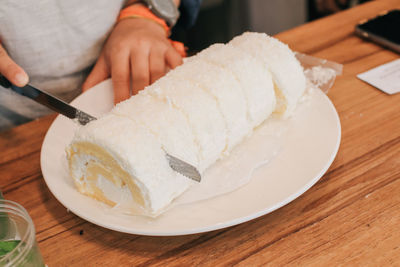 Close-up of hand holding ice cream on table