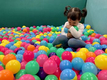 Cute girl sitting in ball pool