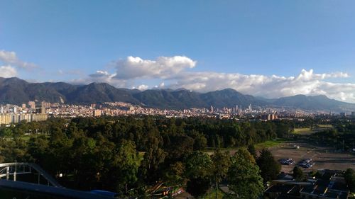 High angle view of trees and mountains against blue sky