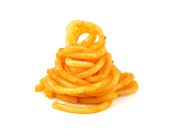 Close-up of orange fries on white background