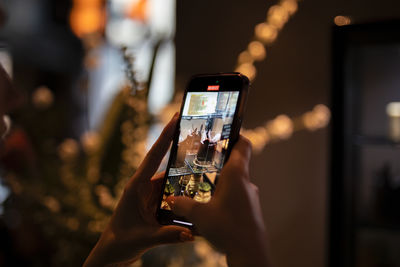 Cropped hand of woman using mobile phone