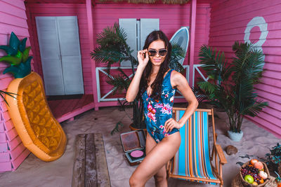 Portrait of young woman wearing sunglasses sitting outdoors