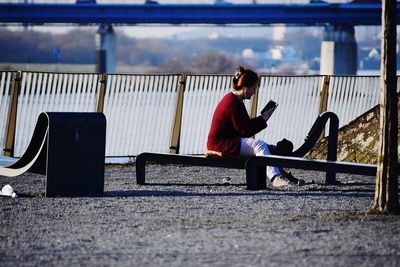 Side view of man sitting on bench