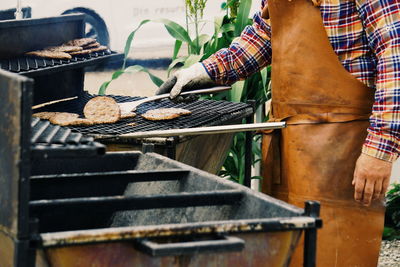 Midsection man preparing food on barbecue grill