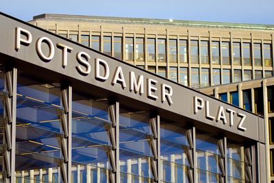 Low angle view of sign against sky in city