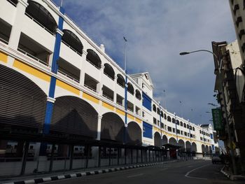 Road by buildings against sky in city