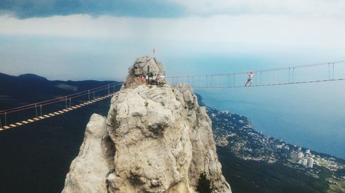 Statue of suspension bridge over sea