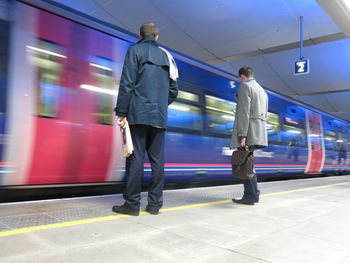 Rear view of men waiting for train