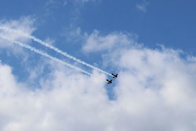 Low angle view of airplane flying against sky