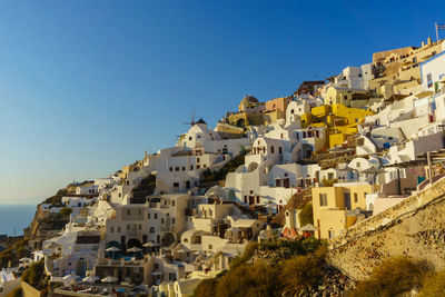 Buildings in town against clear blue sky