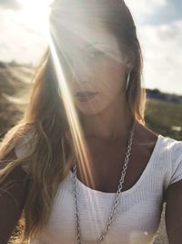 Portrait of beautiful young woman against sky