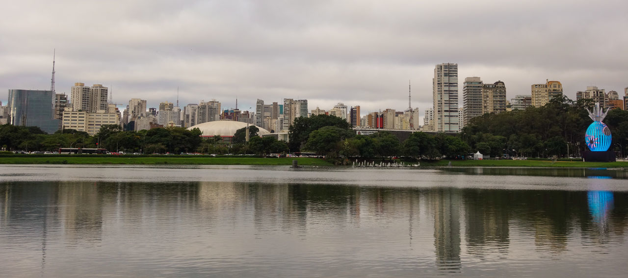 RIVER BY BUILDINGS AGAINST SKY