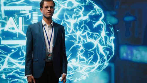 Portrait of businessman standing against wall