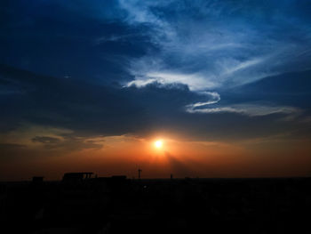 Silhouette city against sky during sunset