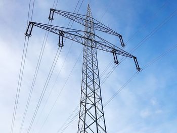 Low angle view of electricity pylon against sky