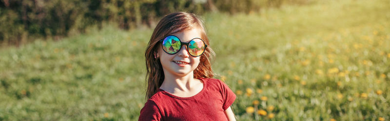 Portrait of girl wearing sunglasses on field