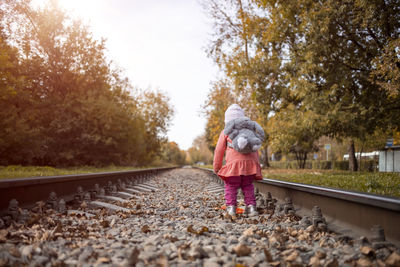 Alone child girl goes traveling alone. little toddler girl on  abandoned railway line.