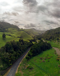 Road amidst green landscape against sky